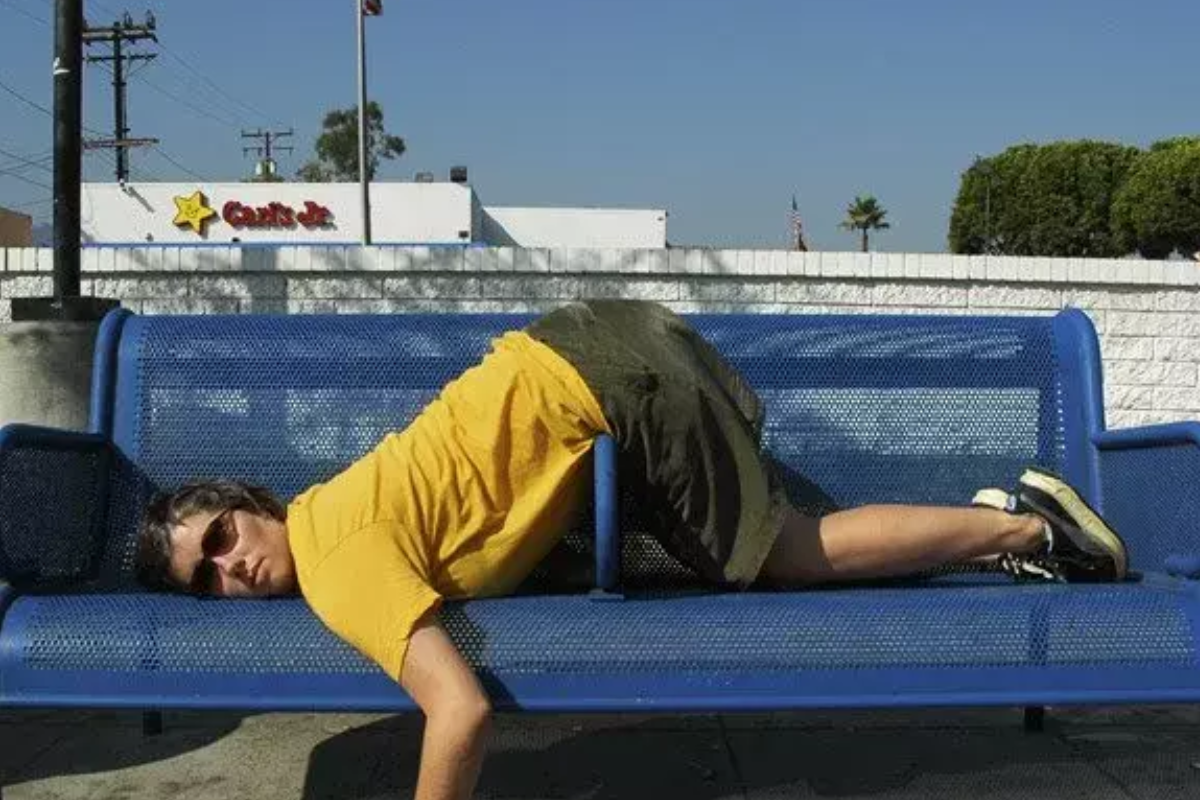 defensive architecture. A Person laying on a bench